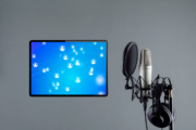 Netzwerk auf Tabletbildschirm mit Podcast-Mikrofon